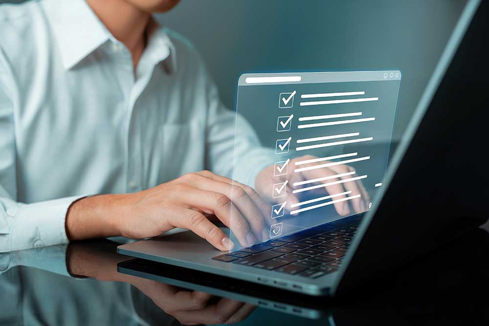 man typing on laptop with with graphic showing checkmarks 